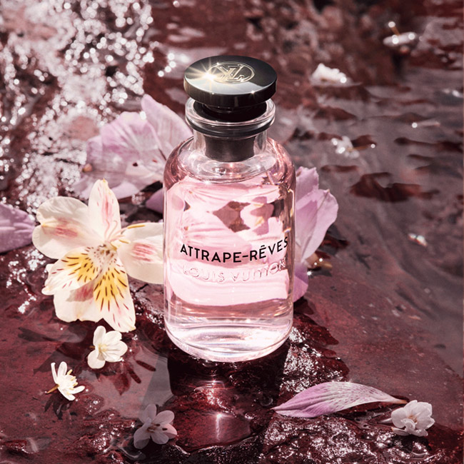 شیشه عطر لویی ویتون اتراپ رو لویی ویتون Louis Vuitton Attrape-Reves در کنار گلبرگهای صورتی و خیس