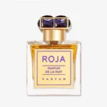 شیشه ی عطر پارفوم د لا نویت روژا داو با درپوش به رنگ یاقوت بنفش و پس زمینه ی سفید