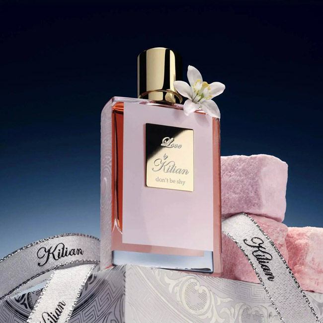 شیشه عطر زنانه کیلیان لاو دونت بی شای کنار قطعات مارشمالو صورتی و گل سفید