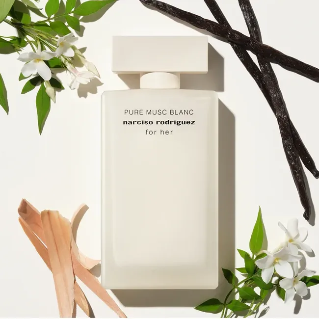 بطری عطر سفید مات نارسیسو رودریگز Pure Musc Blanc for her احاطهشده با گلهای یاس، غلافهای وانیل و چوب صندل