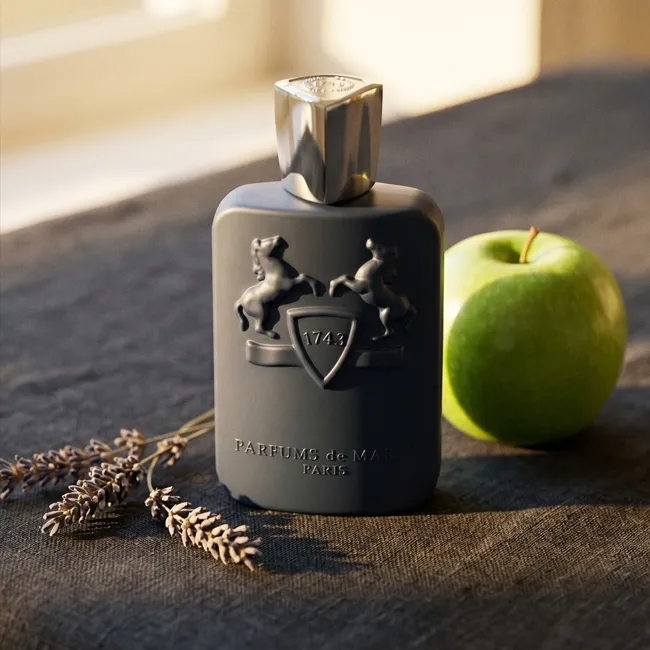 شیشه عطر پارفومز د مارلی لیتون روی پارچه تیره در کنار سیب سبز و اسطوخودوس
