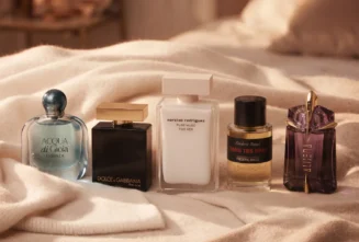 پنج بطری عطر لوکس (آکوآ دی جیویا، دوان، پیور ماسک، دان تس برا، الین) روی پتوهای کشمیری کرم رنگ.