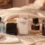 پنج بطری عطر لوکس (آکوآ دی جیویا، دوان، پیور ماسک، دان تس برا، الین) روی پتوهای کشمیری کرم رنگ.